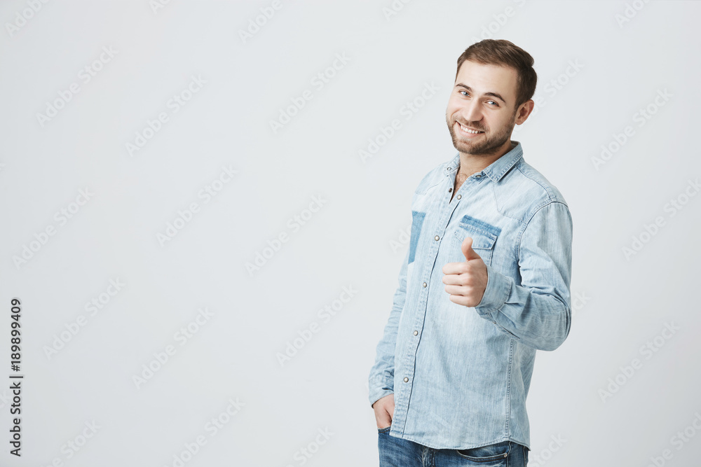 Fotografie Young man holds his thumb up