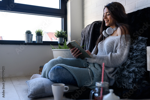 Beautiful woman reading book at home in the morning