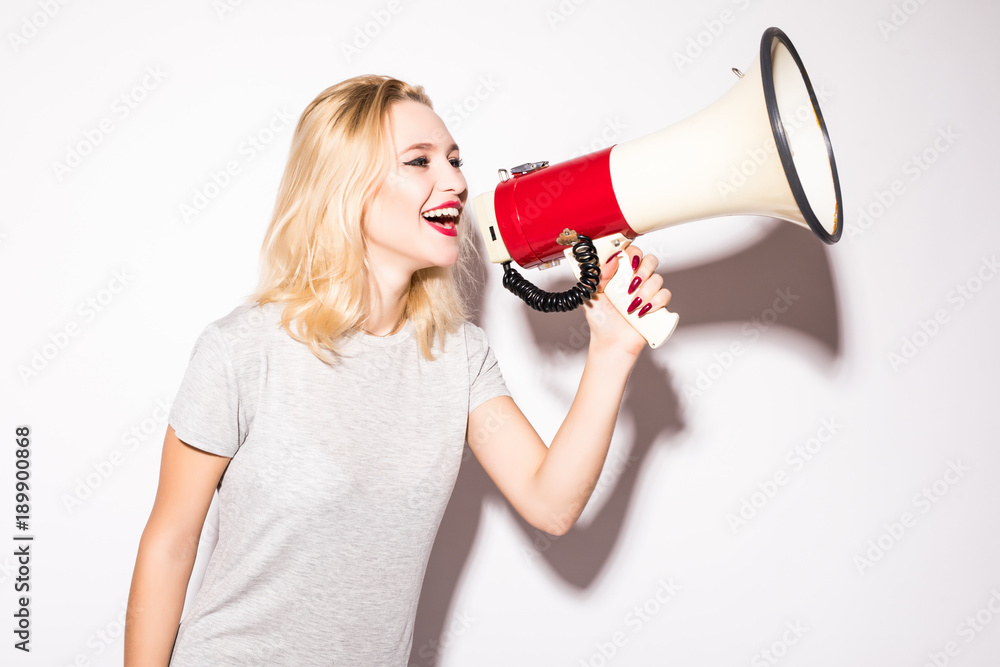 Naklejka premium beautiful shocked woman screaming into megaphone, isolated on white