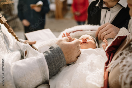 Принти на полотні christening of little baby in church, close-up feet and priest h
