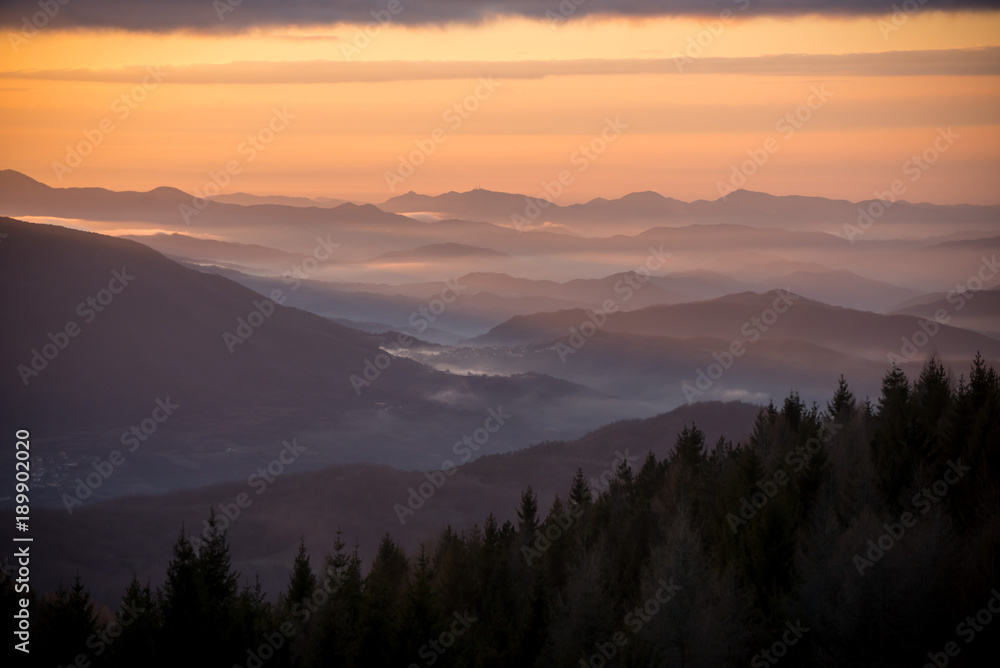 Nebbia al tramonto sulle Alpi italiane in inverno