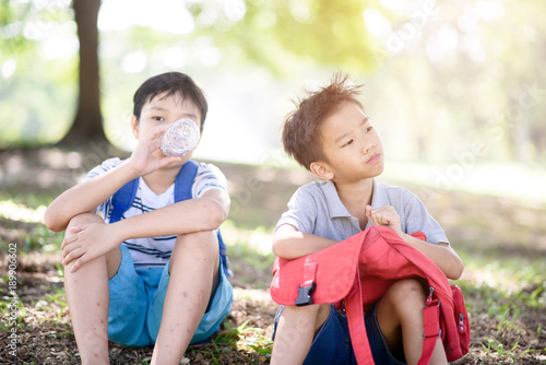 Two boy sit in a park