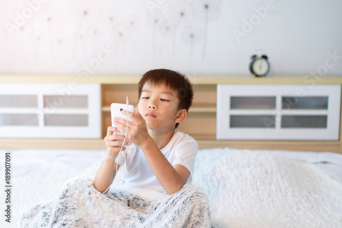 Young Asian boy play game on smartphone