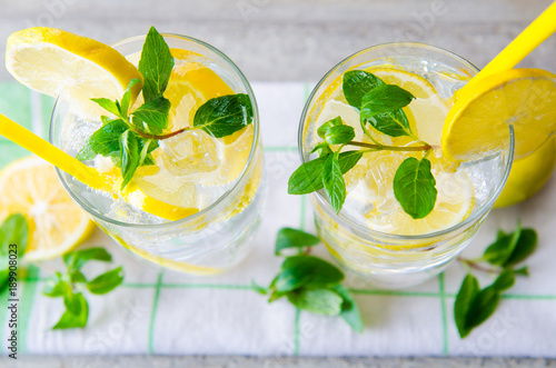 Glasss of mojito with lemon and drinking straw