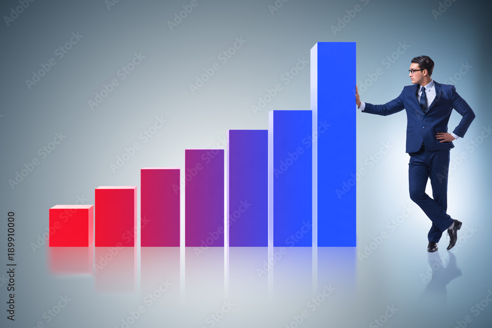 Businessman standing next to bar chart in business concept Businessman standing next to bar chart in business concept