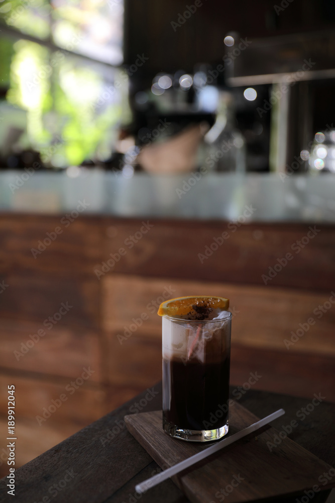 Ice black coffee with orange on wood background Ice black coffee with orange on wood background