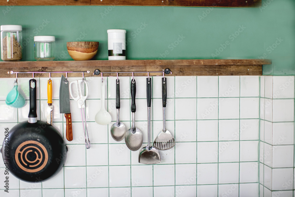 Kitchen utensils on work top in modern kitchen, kitchen accessories hanging  in the roof rail on the green wall Stock Photo | Adobe Stock