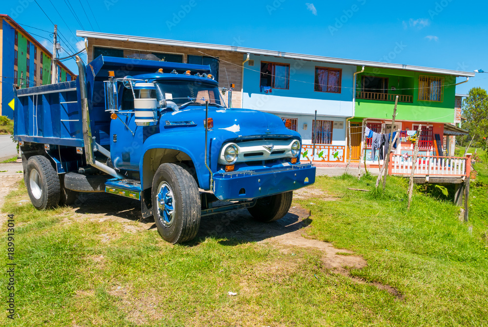 Typical Colombian blue truck and colonial houses in Guatape