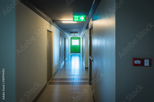 Fire exit sign and fire exit door in building corridor Fototapeta