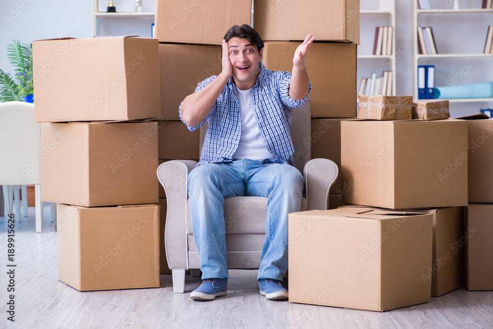 Young man moving in to new house with boxes Young man moving in to new house with boxes