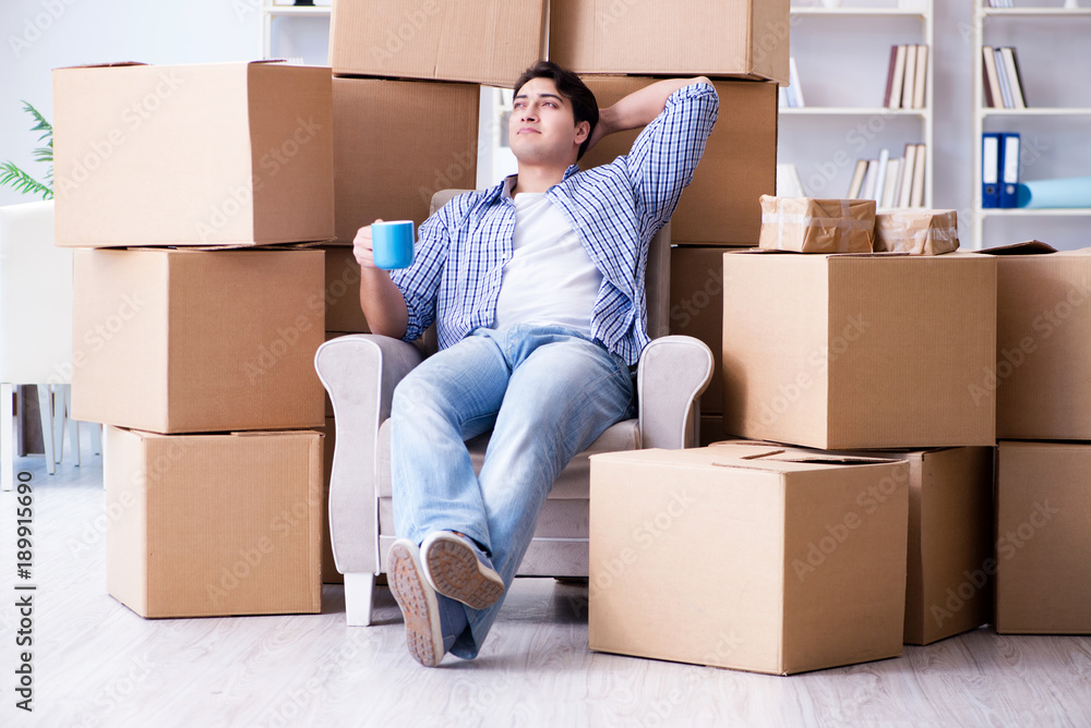 Young man moving in to new house with boxes Young man moving in to new house with boxes