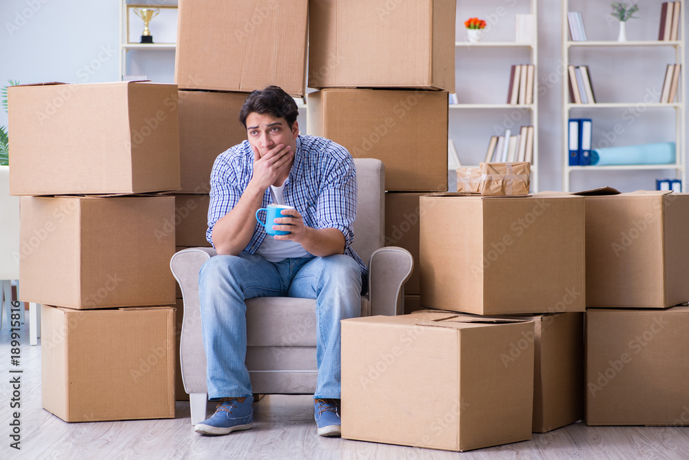 Young man moving in to new house with boxes Young man moving in to new house with boxes