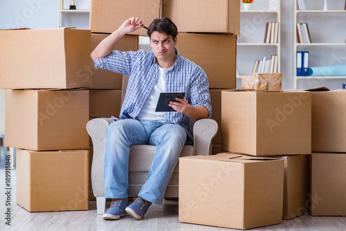 Young man moving in to new house with boxes