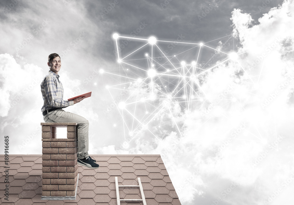 Man on brick roof reading book and concept of social connection Man on brick roof reading book and concept of social connection
