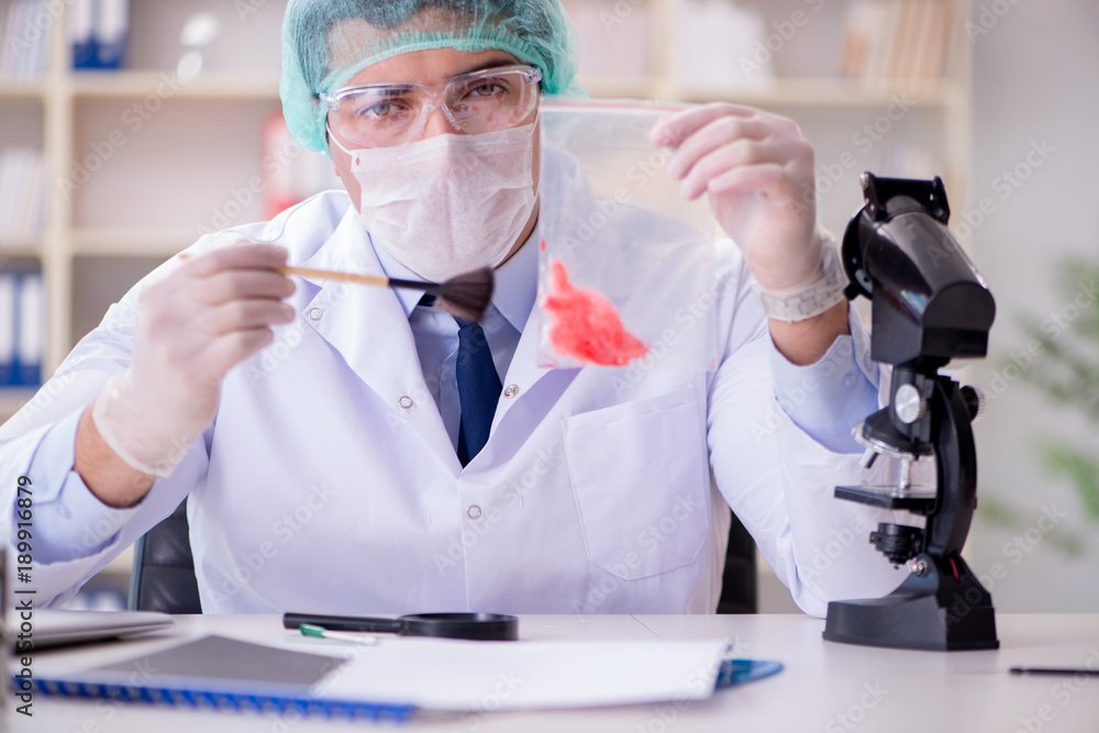 Forensics investigator working in lab on crime evidence Forensics investigator working in lab on crime evidence