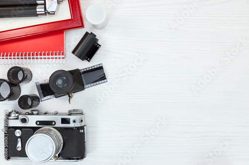 classic film camera, red photo frame, notepad and tripod on white background with copy space. old memories concept.