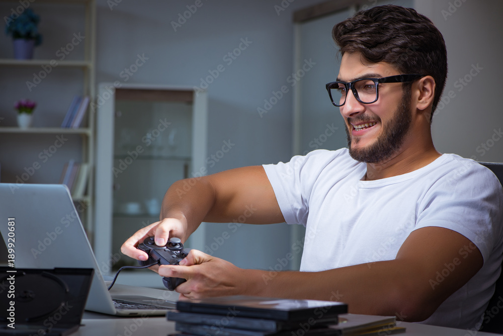 Young man playing games long hours late in the office Young man playing games long hours late in the office