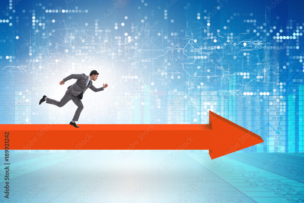 Businessman walking on arrow in business concept Businessman walking on arrow in business concept