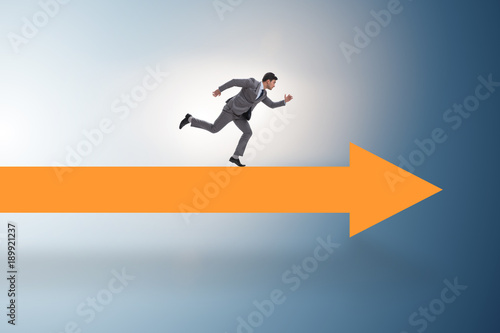 Businessman walking on arrow in business concept