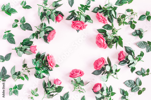 Flowers composition. Frame made of pink rose flowers on pink background. Flat lay, top view, copy space