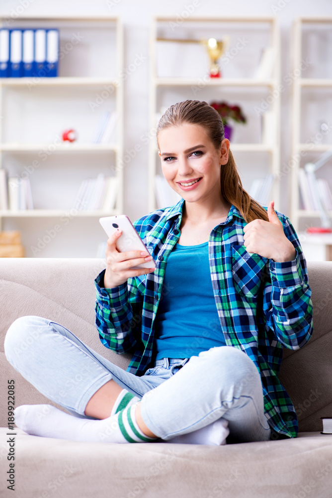 Female student sitting on the sofa with mobile Female student sitting on the sofa with mobile