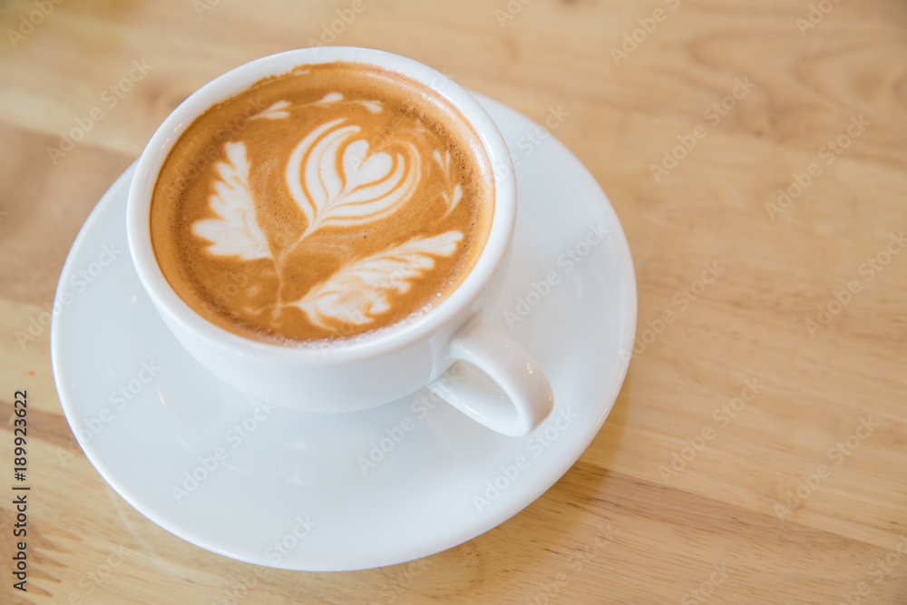 Hot milk latte art coffee on wooden table Hot milk latte art coffee on wooden table