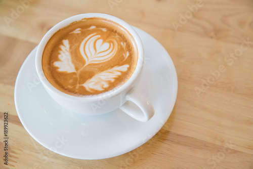 Hot milk latte art coffee on wooden table