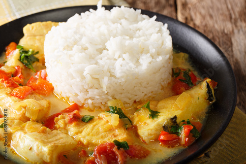 Fish stew in coconut milk with vegetables and rice close-up. horizontal