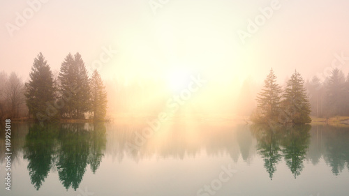 Fototapeta Naklejka Na Ścianę i Meble -  Sunrise at a lake on a foggy morning