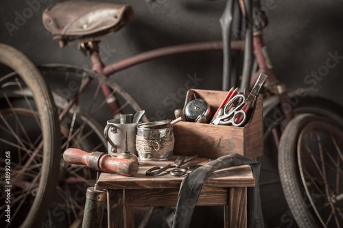 Vintage bicycle repair workshop with tools, wheels and tube