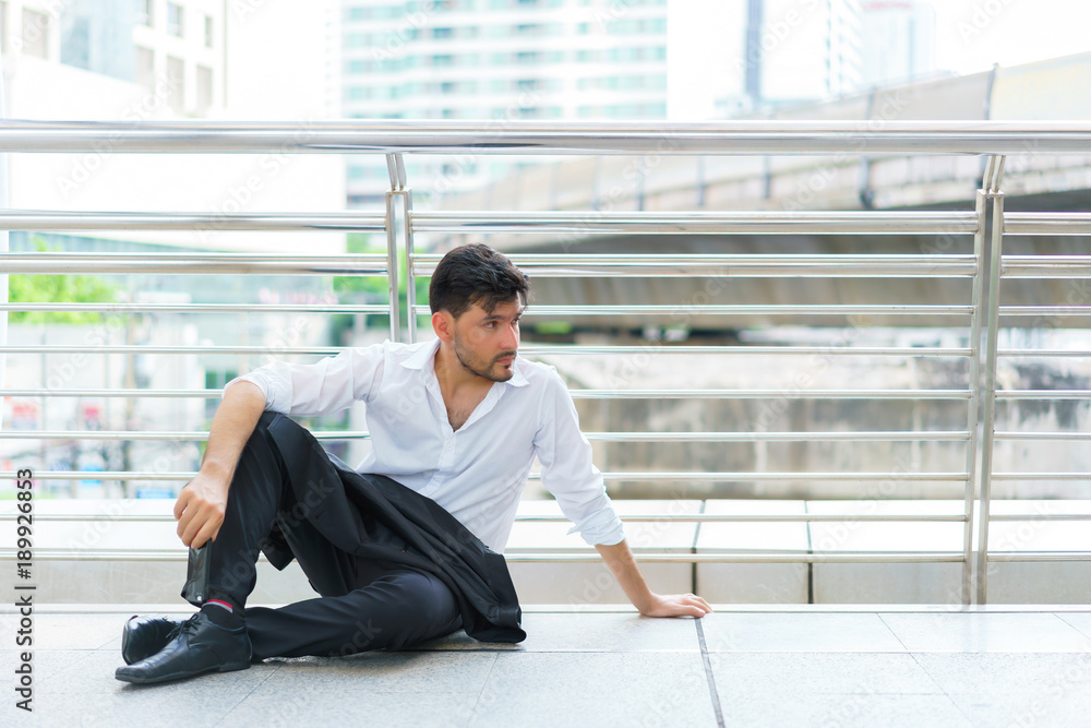 Handsome businessman sitting outdoors. concept of feeling, emotion and attractive. Handsome businessman sitting outdoors. concept of feeling, emotion and attractive.