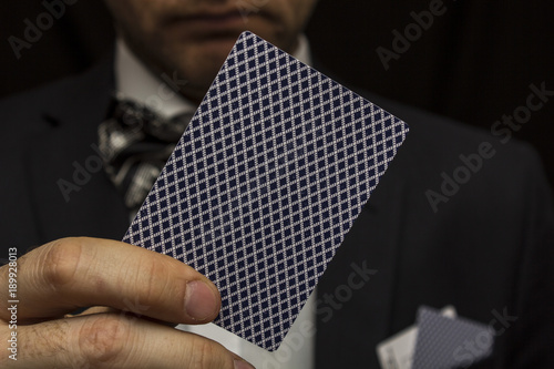 Man with playing cards in suit with bow tie