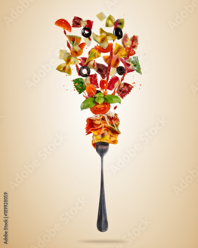 Concept of flying food with fork and traditional italian farfalle pasta