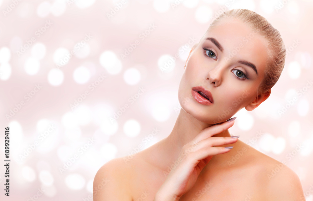 Beautiful young woman with smooth and soft, clear skin against an bstract background with blurred lights Beautiful young woman with smooth and soft, clear skin against an bstract background with blurred lights