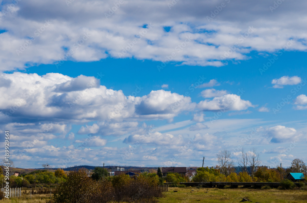a country landscape with houses and clouds above a country landscape with houses and clouds above