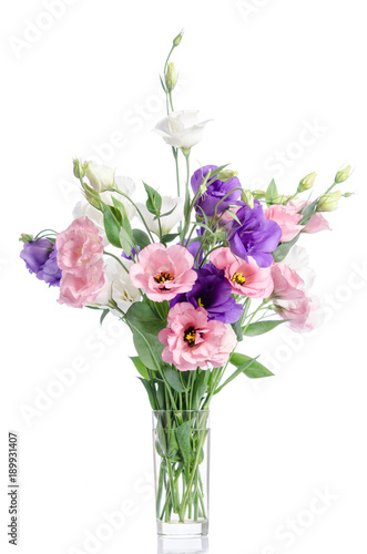 bunch of violet  white and pink eustoma flowers in glass vase isolated on white