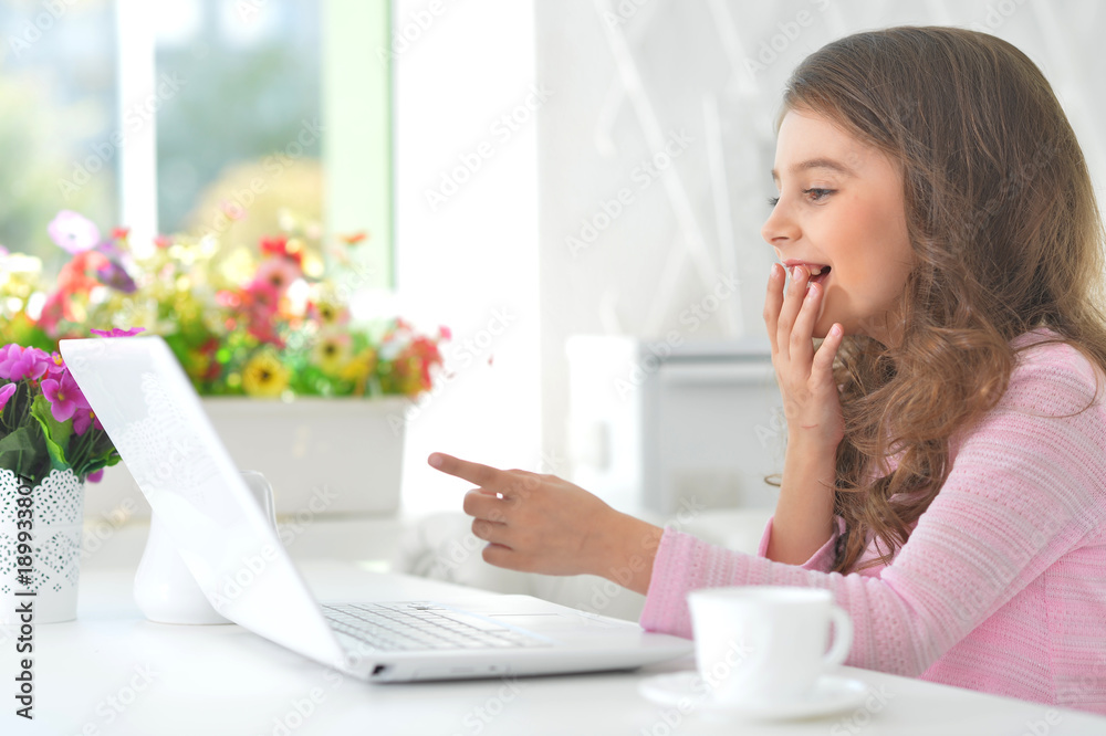 little girl sitting at the table with laptop little girl sitting at the table with laptop