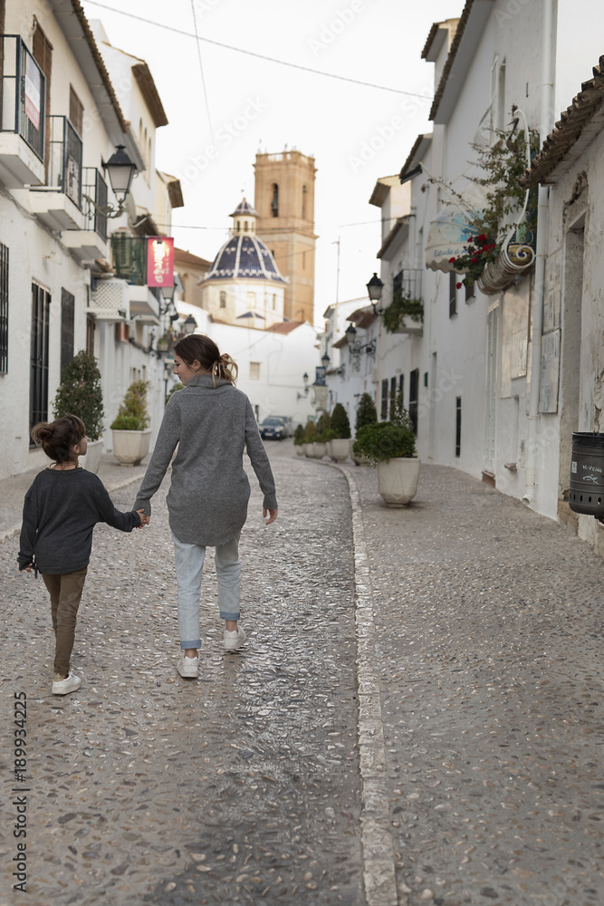 Two Sisters walking hand in hand through the town of Altea.