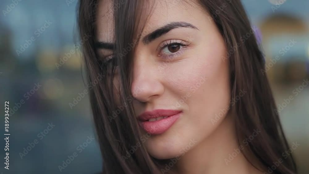 Beautiful girl smile in the evening. hair close her face. A brunette woman in a black leather jacket. Clouse up view. Beautiful girl smile in the evening. hair close her face. A brunette woman in a black leather jacket. Clouse up view.