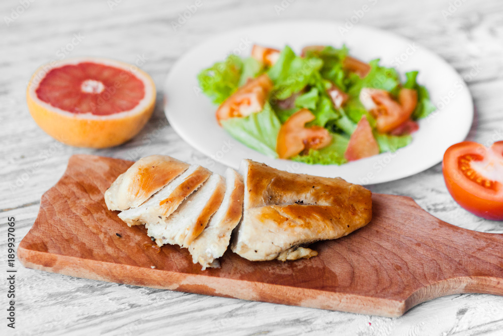 cooking a healthy fresh salad with chicken, grapefruit, cheese and tomatoes