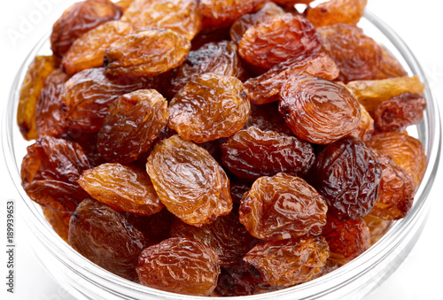 bowl of raisins on a white background. Dried grapes.