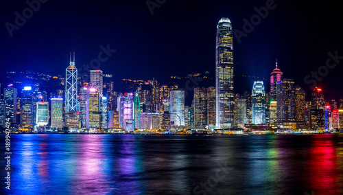 Hong Kong, China. August 30, 2017. Skyline at night with lights and skyscrapers over sea with laser beams.