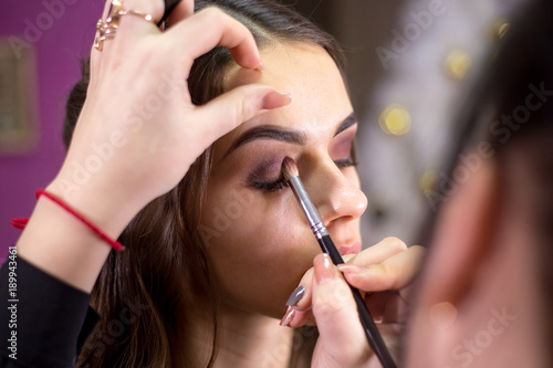 Make-up artist makes make-up an attractive model