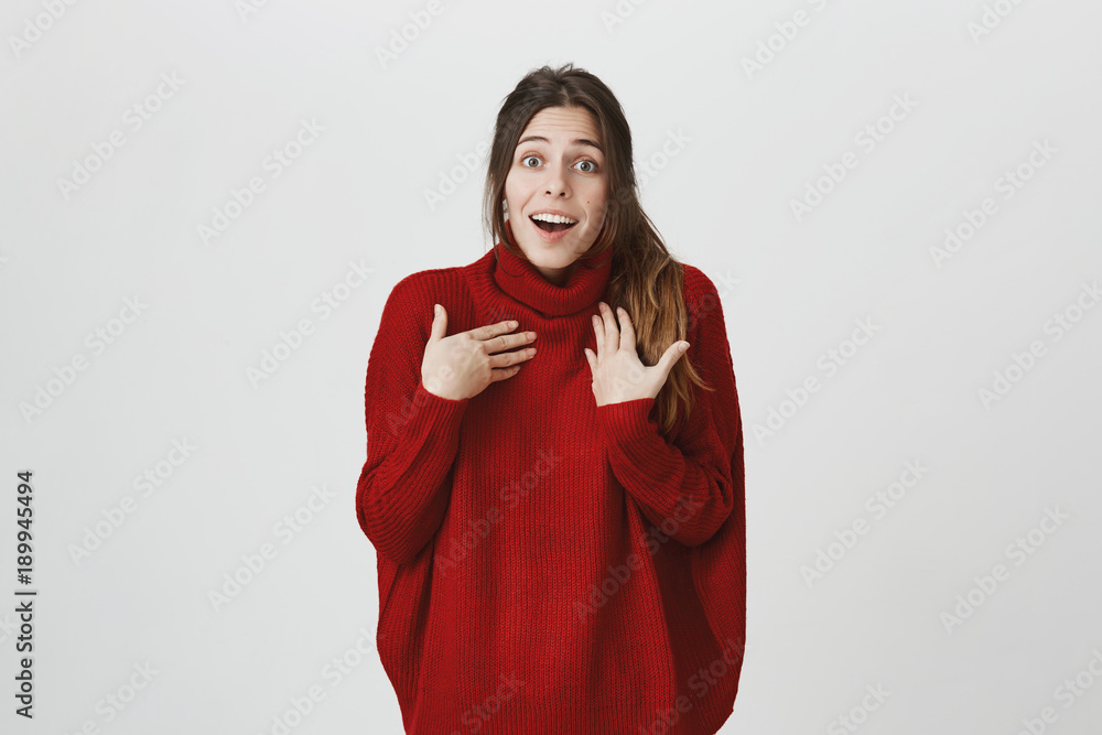 Pretty beautiful woman with dark long hair looking at camera having excited and happy facial expression, exclaiming, posing against blank studio wall, expressing her excitement with present Pretty beautiful woman with dark long hair looking at camera having excited and happy facial expression, exclaiming, posing against blank studio wall, expressing her excitement with present