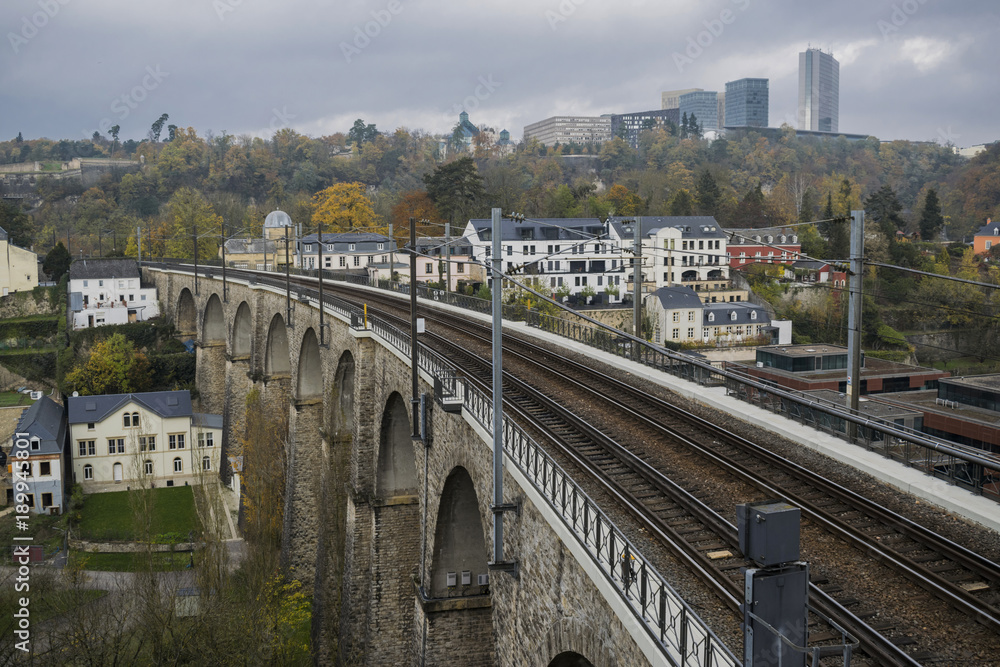 Detail of electrical railroad in Luxembourg city with rails, contact lines and viaduct structures in dark autumn day illustrating urban transport concept, Luxembourg. 