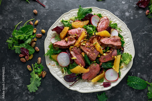 Duck breast fillets steak salad with orange halves, radishes and crushed pistachios