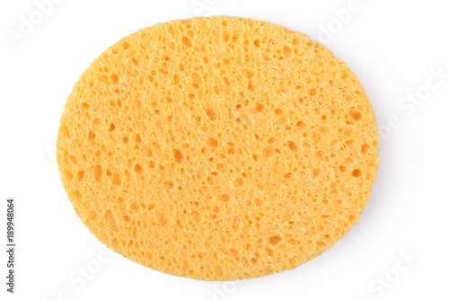Oval yellow sponge cleansing puff for face or cleaning surface texture isolated on white background on top view photo