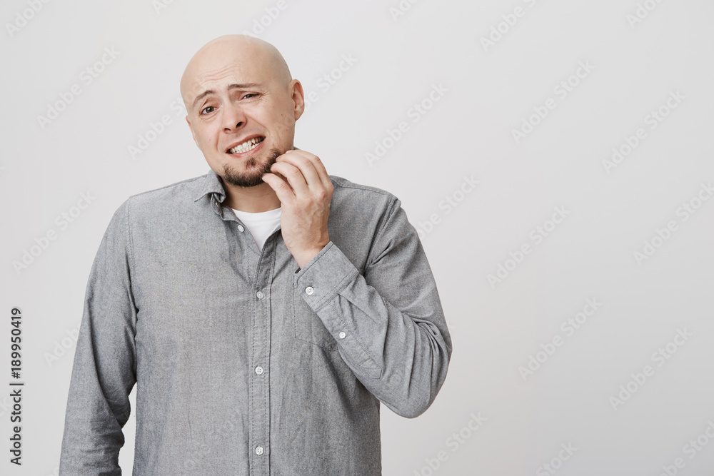 Headshot of clueless bald bearded caucasian man looking at camera with confused and puzzled expression, frowning, having forgot about something, scratching his beard. Face expression and emotions Headshot of clueless bald bearded caucasian man looking at camera with confused and puzzled expression, frowning, having forgot about something, scratching his beard. Face expression and emotions