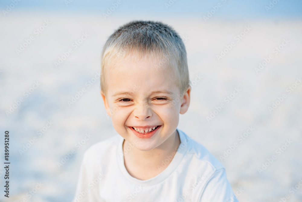 Adorable portrait of a happy boy, smiling at the camera in the sand near the sea, ocean. Positive human emotions, feelings, joy. Funny cute child taking vacations and enjoying summer. Adorable portrait of a happy boy, smiling at the camera in the sand near the sea, ocean. Positive human emotions, feelings, joy. Funny cute child taking vacations and enjoying summer.
