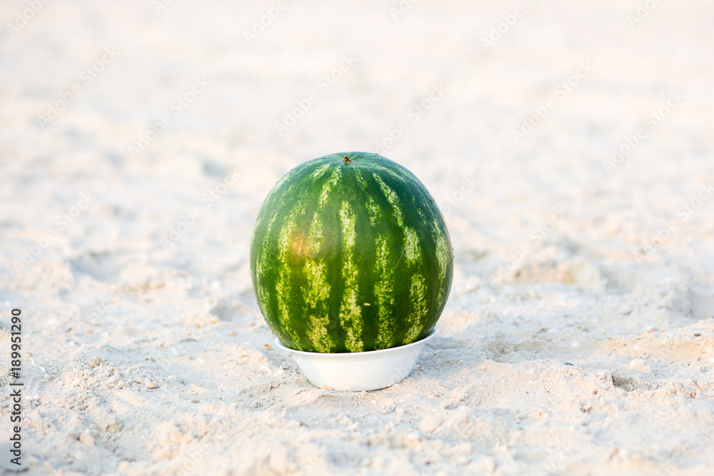 Watermelon fruit on white plate on the beache. Tropical summer vacation concept. Watermelon fruit on white plate on the beache. Tropical summer vacation concept.